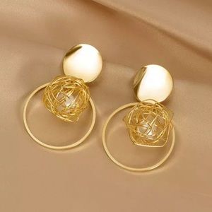 Gold dangle earring with pearl nested inside.